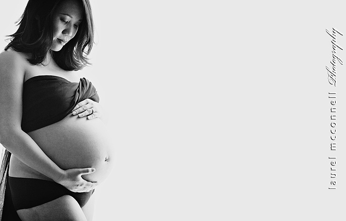 B&W image of a maternity photography shoot of a woman with a bare belly by Seattle Belly and Baby photographer Laurel McConnell